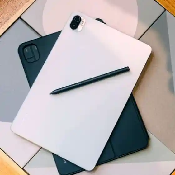 Xiaomi Pad 5 pro on a table and a stylus on top of it.